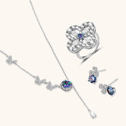 Sterling silver jewelry set with rainbow moissanite stones in clover and butterfly designs on cream background