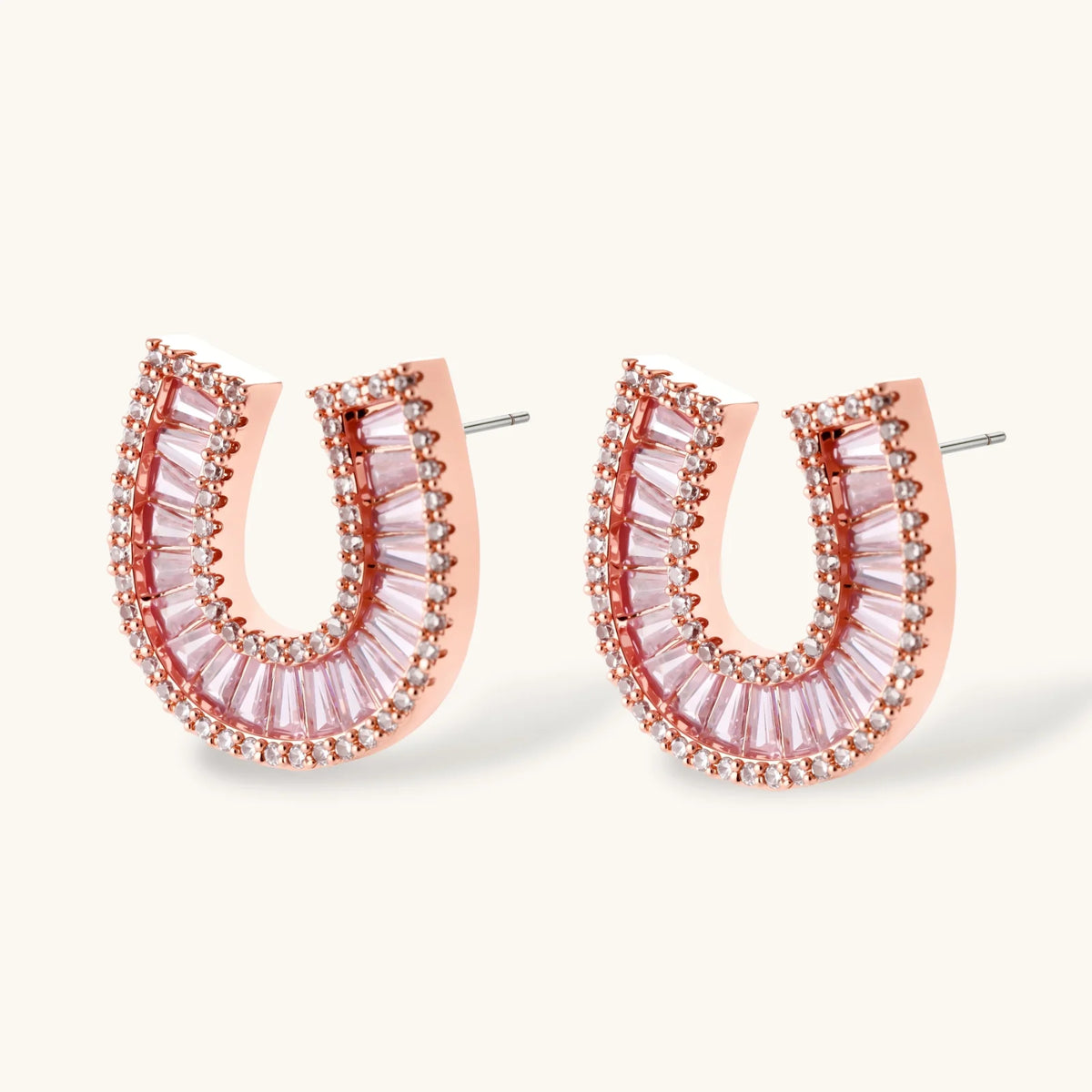 Rose gold-plated horseshoe pendant necklace and matching stud earrings set with pink baguette zirconia stones.