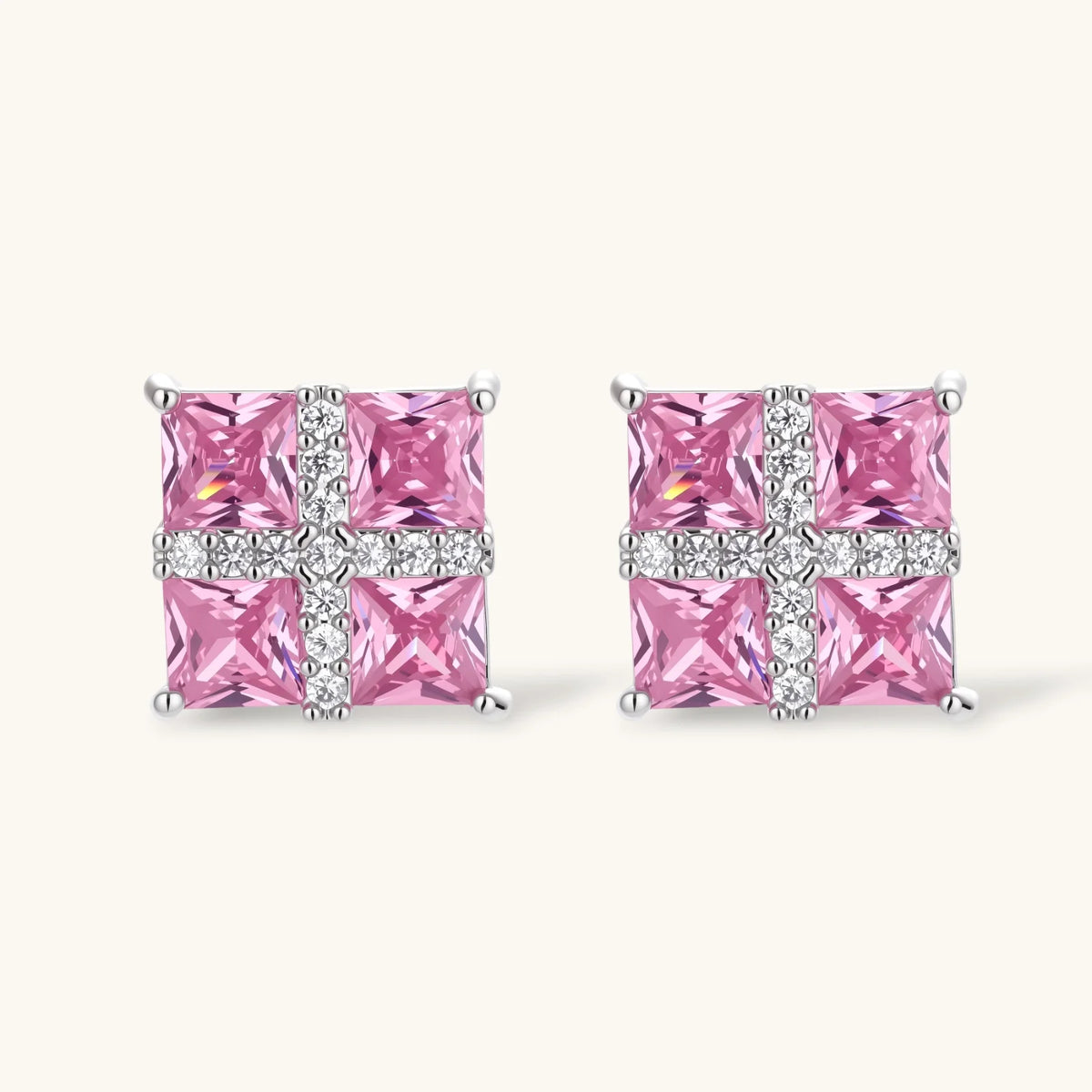 Necklace and stud earrings set with four pink square zirconia stones and a white crossed band, on a cream background.