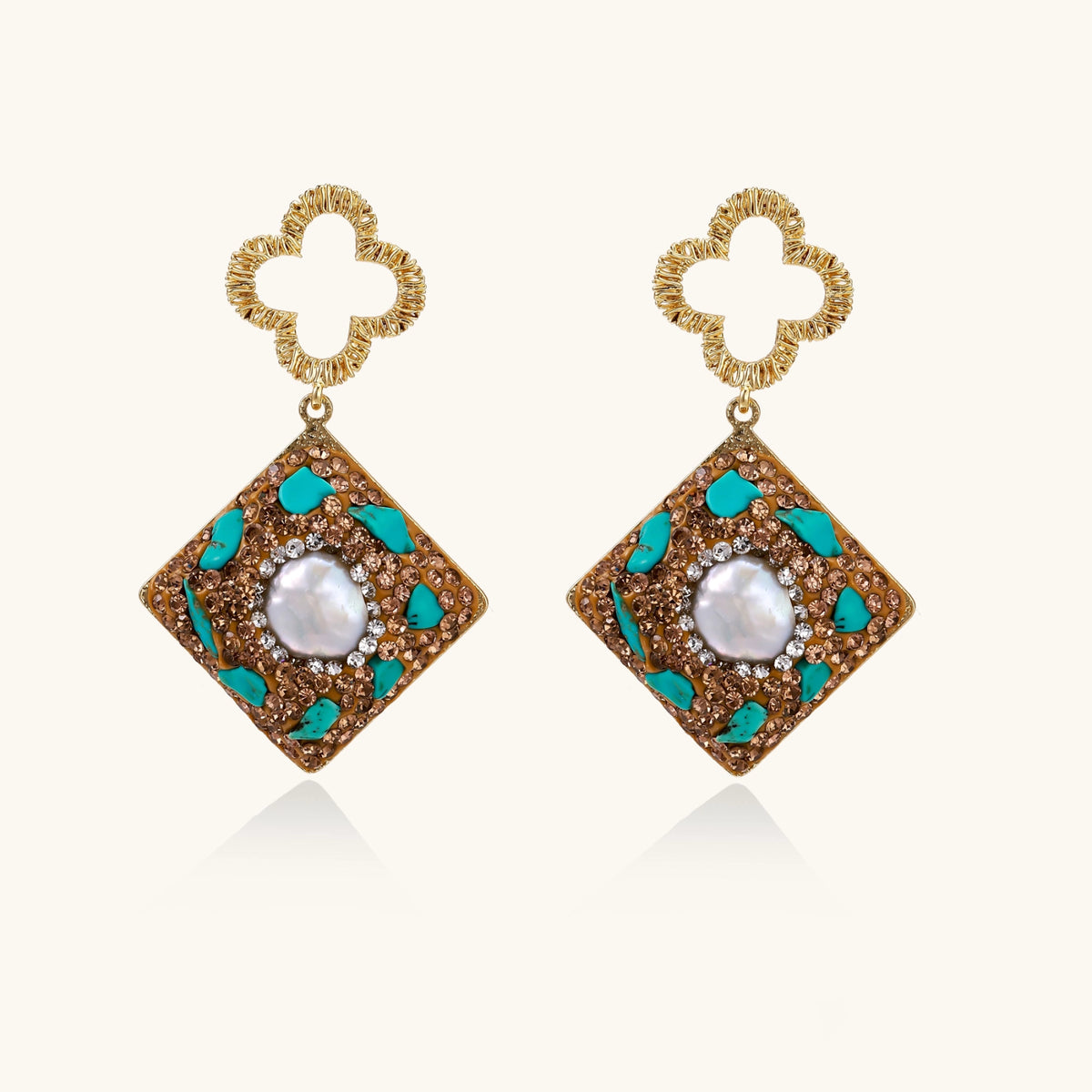 Gold-plated drop earrings with quatrefoil studs, diamond-shaped pendants featuring baroque pearls, turquoise stones, and amber crystals