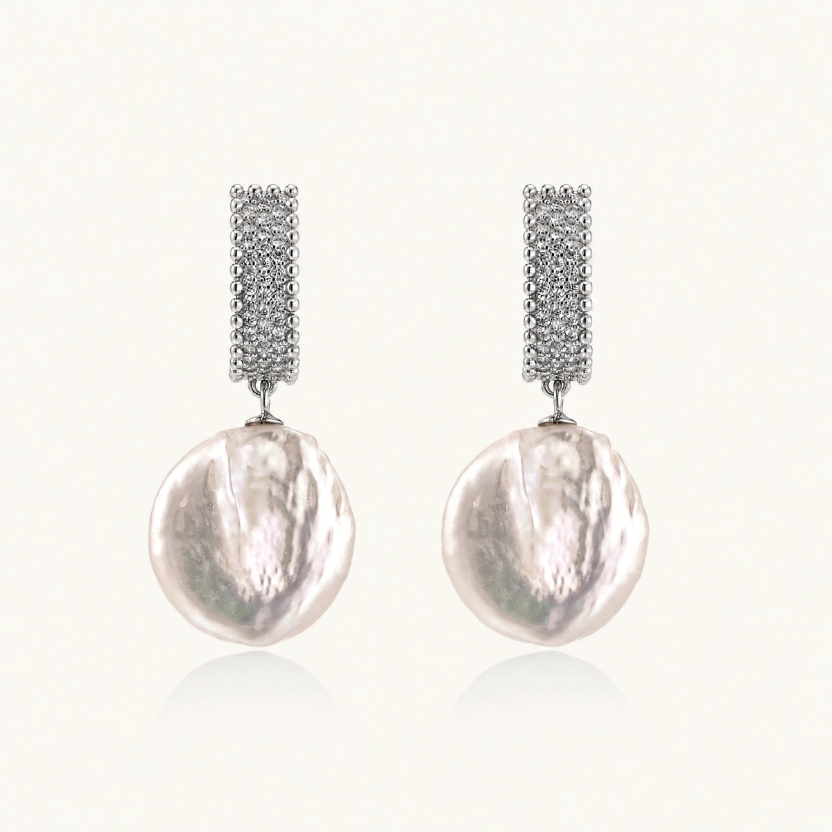 Rhodium-plated silver curved stud with pave stones and baroque pearl drop on white background