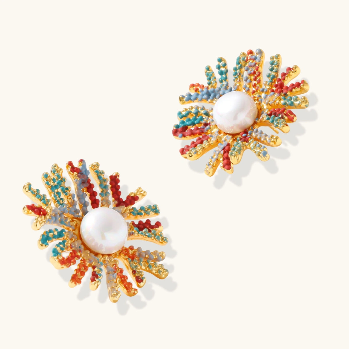 Vibrant starburst stud earrings with multicolor enamel rays and white pearl centers on gold-plated setting