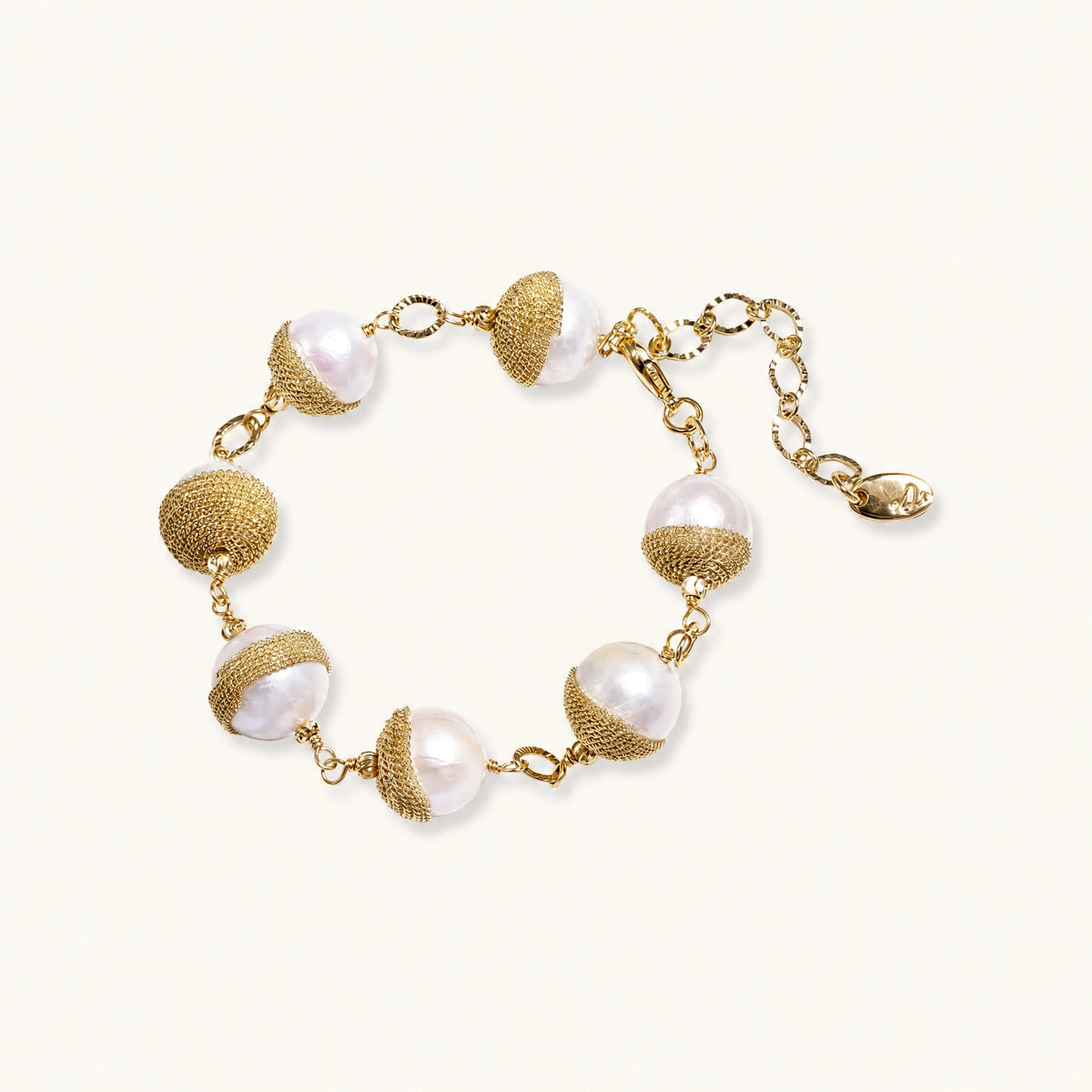 Adjustable bracelet with baroque pearls wrapped in delicate gold mesh netting connected by textured chain links